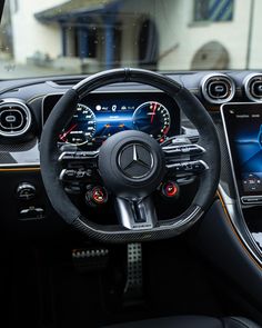 the interior of a mercedes c - class coupe with its steering wheel and dashboard controls