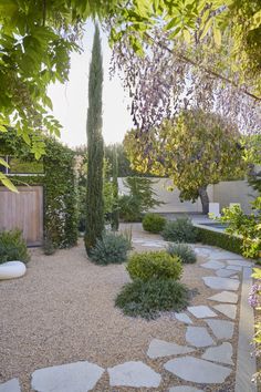 an outdoor garden with stone walkways and trees