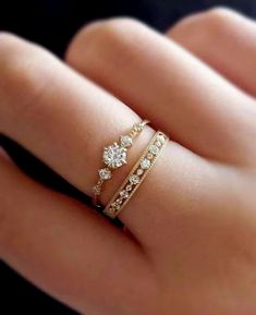 a woman's hand with two rings on it and one is holding the other