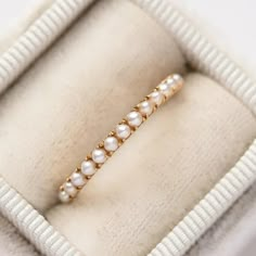 a pearl and gold ring in a box