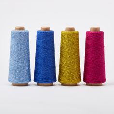 three spools of thread are lined up next to each other in different colors