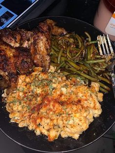 a plate full of food with chicken, green beans and mashed potatoes on it