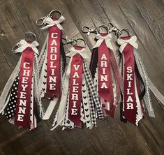 five red and white ribbon keychains with the words carolina written on each one