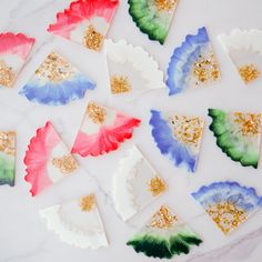 colorful paper plates with gold glitters and confetti on them sitting on a marble surface