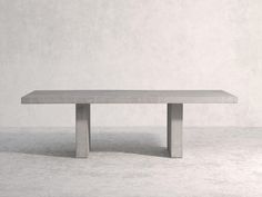 a concrete table sitting on top of a white floor next to a gray wall with no one around it