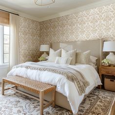 a bedroom with a large bed and two lamps on either side of the window sill