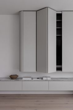 an empty kitchen with white cabinets and marble counter tops