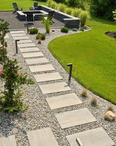 an outdoor patio with stone steps leading up to the back yard and picnic table in the background