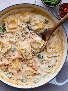 a skillet filled with ravioli and spinach