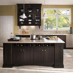 a large kitchen with an island in the middle and lots of cabinets on both sides