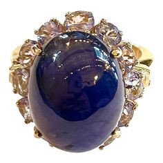 This is part of Chairish’s Fine Jewelry assortment.  Blue Sapphire Cabochon - 12 Carat Lilac Tanzanite   - 3 Carats  This Ring is from the "Orient" traveling collection are the epitome of elegance and versatility. It offers a perfect blend of day to night and swimwear to evening wear, allowing you to effortlessly transition between different occasions and outfits. Wearing these spectacular oriental-style ring will undoubtedly make you the center of attention. It addw a touch of glamour and sophi Luxury High Luster Gemstones For Formal Occasions, Formal Fine Jewelry Cabochon Gemstones, Fine Jewelry Cabochon Gemstones For Formal Occasions, Blue Classic Cabochons For Formal Occasion, Classic Blue Cabochons For Formal Occasion, Formal High Luster Blue Jewelry, Luxury Blue Cabochons For Anniversary, Blue Formal Classic Cabochons, Collectible Sapphire Gemstone Rings