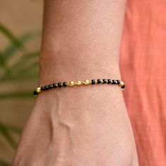 "Single strand gold chain bracelet with black beads and gold balls, handcrafted with love and care, this comfortable bracelet is a perfect accessory for everyday wear. Lightweight and stylish..! * Length : 5.5\" to 9\" + 0.5\" extender eg : 6\" length will fit wrist size of 6\"- 6.5\" * Gold : 18k Solid Yellow Gold * Gold Weight - 2.5 gms approx for 5.5\" inches with extender - For longer/shorter length, please ask for a quote before placing the order. If you like this bracelet, please press \"P Black Bracelet With Gold Beads, Gold Rosary Bracelet With Black Beads As Gift, Black Beaded Chain Bracelet For Gift, Black Beaded Bracelets With Gold Beads For Gifts, Gift Black Beaded Chain Bracelet, Gold Spiritual Beaded Chain Bracelet, Black Beaded Bracelet As Gift, Black Bracelets With Tiny Beads As Gift, Yellow Gold Bracelets With Black Beads As Gift