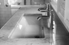 two faucets on one sink - transstinal to the other in black and white