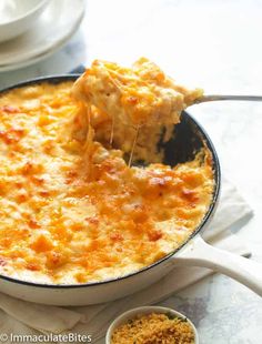 a casserole dish with cheese being lifted from the skillet by a spatula