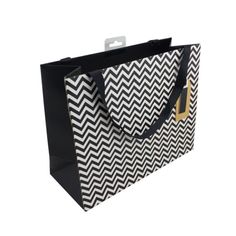 a black and white chevroned shopping bag with gold accents on the handles,