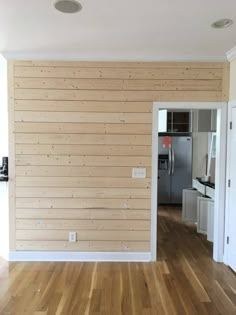 an empty room with wood paneling on the walls and hard wood floors in it