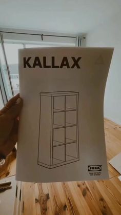 a person holding up a piece of paper with the word kallax on it