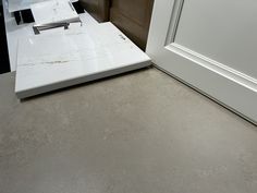 a kitchen counter with a white marble top next to a door and brown trim on the wall