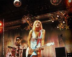 an image of a woman playing guitar on stage