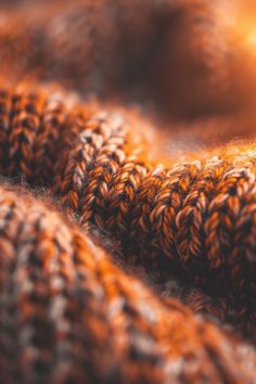 an orange knitted blanket with the sun shining in the backround behind it