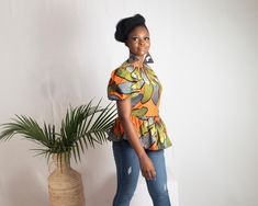 Brighten up your wardrobe with the NAFULA African Print Ankara Top in a vibrant orange design. This peplum top features bold prints that celebrate African heritage, with a flattering fit that enhances your silhouette. The puffed sleeves add a touch of elegance, making it perfect for both casual and semi-formal events. Features: - Handmade in Nigeria - African Print Top - Peplum Style - Rounded Neck - Short Sleeves - Length: 24 Inches - Zip Fastening to the back Important Note: This item is part African Print Peplum Top, African Print Top, African Print Tops, Printed Peplum Top, Peplum Styling, Peplum Styles, Orange Design, Puffed Sleeves, Vibrant Orange