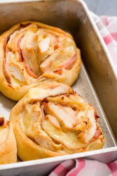 ham and cheese pastry rolls in a baking pan on a checkered table cloth, ready to be eaten