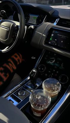 the interior of a car with drinks in plastic cups