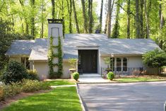 a white house with trees and bushes around it