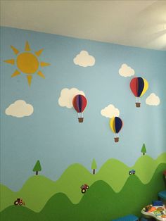 a child's room with hot air balloons painted on the wall and clouds in the sky