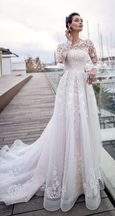 a woman in a wedding dress standing on a dock