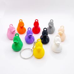 a bunch of different colored plastic objects on a white surface with a keychain