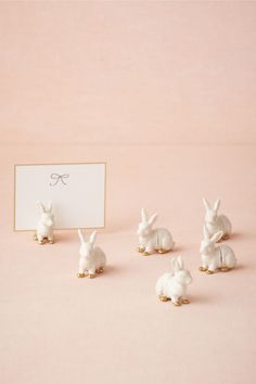 small white rabbit figurines sitting next to a card