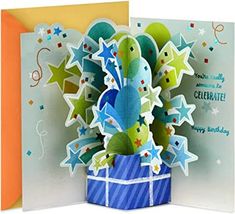 a birthday card with an origami tree in a gift box and stars on it