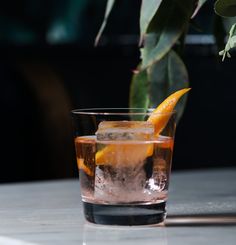 an orange slice sitting on top of a glass filled with ice