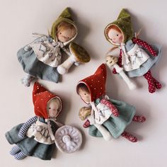 four little dolls dressed in clothes and hats