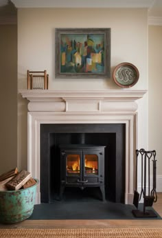 a fire place in a living room with a painting on the wall