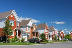 a row of houses with cars parked on the street