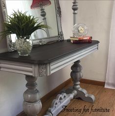 a wooden table topped with a potted plant next to a mirror