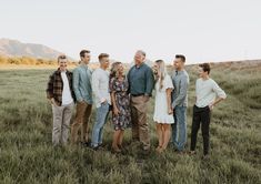 a group of people that are standing in the grass and posing for a picture together