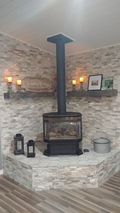 a wood burning stove sitting inside of a living room next to a wall with pictures on it