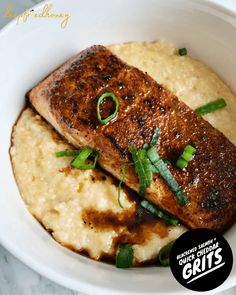 a white bowl filled with meat and mashed potatoes on top of a marble table