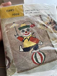 a person holding up a piece of cloth with a clown on it