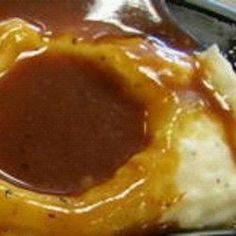 a piece of bread covered in cheese and gravy sitting on top of a table