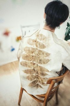 a woman sitting in a chair with her back turned to the camera and looking at an x - ray