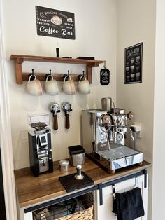 an espresso machine sitting on top of a wooden counter next to a shelf