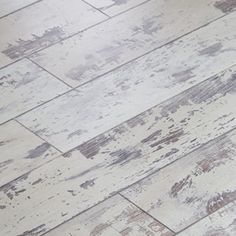 an old white wood floor with chipped paint on the top and bottom part of it