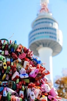 a large pile of colorful magnets in front of a tall building with a sky scraper behind it