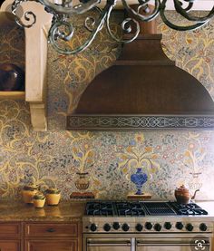 a stove top oven sitting inside of a kitchen under a chandelier above it