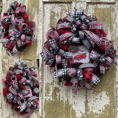 two red and black christmas wreaths hanging on the side of an old wooden door