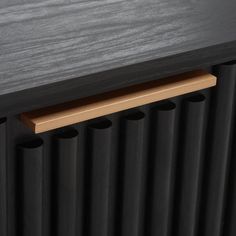 a close up view of a black radiator with wood trim on the side